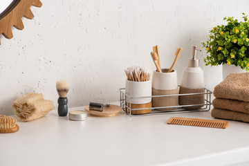 Different beauty and hygiene objects with flowerpot in bathroom, zero waste concept