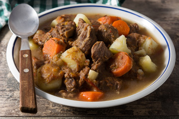 Irish beef stew with carrots and potatoes on black background