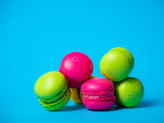 A lot of little colored macaroons on a blue background.