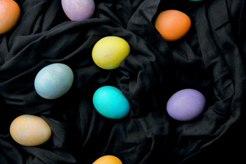 Colorful eggs and lollipops on a black background, Easter.