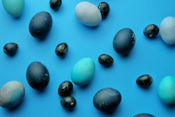 Easter chicken and quail eggs on a pastel blue background. The view from the top. Easter concept.