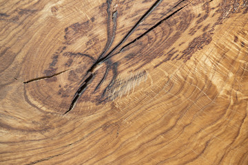 Natural wooden background with beautiful streaks. A crack in the place of the knot. A whole piece of wood