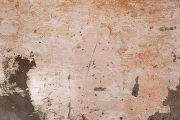 Grunge background with old stucco wall texture of beige color. cracks