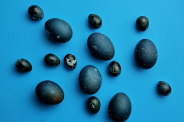 Easter chicken and quail eggs on a pastel blue background. The view from the top. Easter concept.
