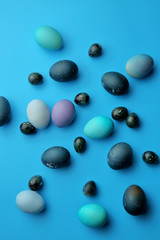 Easter chicken and quail eggs on a pastel blue background. The view from the top. Easter concept.