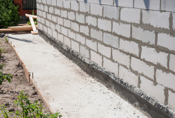 House foundation wall with waterproofing protection path from concrete