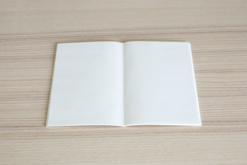 Mock up blank open paper book on wood table background