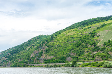 Fototapeta na wymiar Germany, Rhine Romantic Cruise, a close up of a hillside next to a body of water