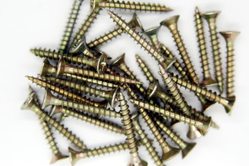 a bunch of self-tapping screws in close- up on a white background