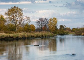 Fototapeta na wymiar Autumn colors reflect in the smooth surface of the DuPage River