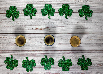 Flat lay composition with clover leaves and glasses of beer on wooden background. Saint Patrick's...