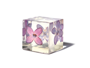 Beautiful simple violet and white background suitable for text input. Handmade epoxy resin cube with lilac flower, isolated on white background. Illustration.