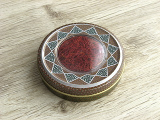 Iranian saffron into handcraft box on wooden background. Iranian saffron for export.