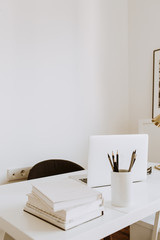 Modern minimal interior design concept. Bright Scandinavian home office desk table workspace with laptop, books. Business study cabinet.