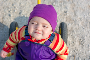 Cute baby girl posing on her bycicle outdoor.