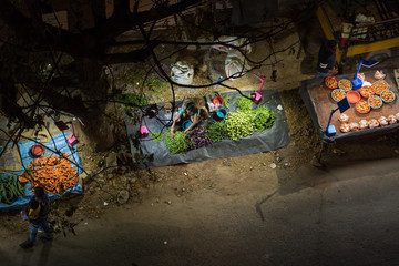 Market stall with woman selling vegetables in India