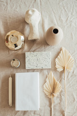 Lifestyle, still life composition with home decoration: book, fan leaves, granite brick, bust,...