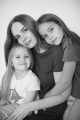mom and two daughters hug each. black-white. 
