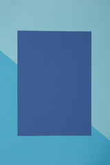 Blue background, colored paper geometrically divides into zones, frame, copy, space.