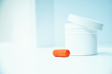 Red capsule pill antibiotic against influenza virus, orvi, coronavirus on a white-blue background.