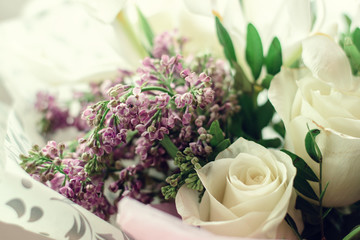 Gentle spring bouquet of white roses,white irises,lilac and freesia in gift wrapping.Present concept for Valentine's Day,Birthday, wedding,mother's Day.