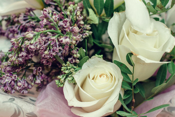 Gentle spring bouquet of white roses,white irises,lilac and freesia in gift wrapping.Present concept for Valentine's Day,Birthday, wedding,mother's Day.