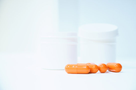 Red pills on a white ahite background. Antibiotic for diseases of the coronavirus ncov-19, influenza, acute respiratory viral infections and colds. Treatment and medicines.