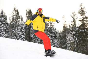 Fototapeta na wymiar Male snowboarder on snowy hill. Winter vacation