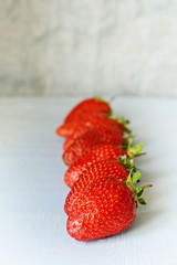 Ripe fresh organic strawberries on a blue background, place for text. Juicy Summer Berries.