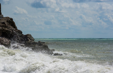 sea landscape is a pebbly beach with waves in white foam
