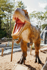 Artificial brown dinosaur by fence in miniature golf course © Cavan for Adobe