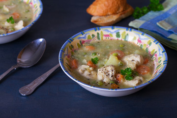 Bowl of chicken stew with vegetables on dark gray background. horizontal image