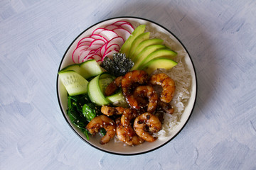 Shrimps prawns with rice, avocado, spinach, radish cucumber and  seaweed. Healthy food concept. Overhead horizontal image