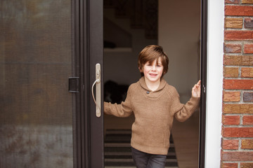 Portrait of cute smiling boy standing at window © Cavan for Adobe