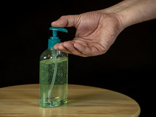 Liquid disinfection on wooden table used to wash hands, black background
