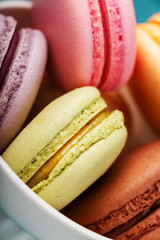 Multicolored French macaron cookies close-up, filling macro.