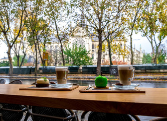 Cups of coffee and delicious deserts in a café opposite to Notre-Dame de Paris cathedral, France