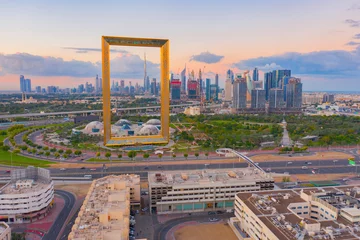 Fotobehang Luchtfoto van Dubai Frame, Downtown skyline, Verenigde Arabische Emiraten of Verenigde Arabische Emiraten. Financiële wijk en zakenwijk in slimme stedelijke stad. Wolkenkrabber en hoogbouw bij zonsondergang. © tampatra