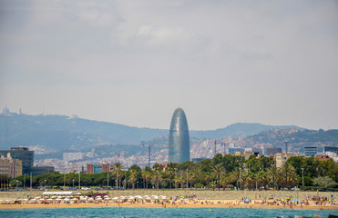 View of Barcelona, Barceloneta beach, modern glass windows tower Agbar and the Mediterranean sea on...
