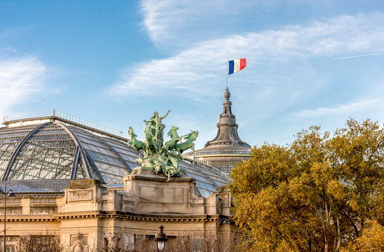 One of two quadrigas sculptures and a French flag raised at Grand Palais museum building, Paris, France. Sculptor: Georges Recipon (1860-1920)