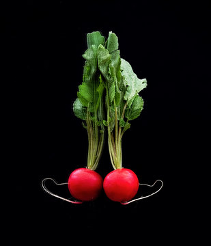 Red Radish And Its Reflection At Black Mirror Background