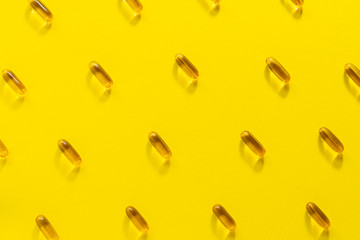 Cod lover oil omega 3 capsules on yellow background. Health care concept. 