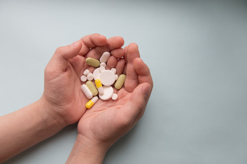  children hands holding pills on blue background