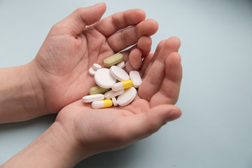  children hands holding pills on blue background