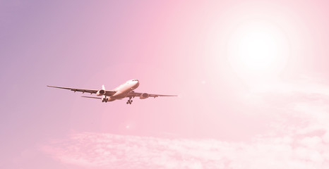 Passenger airliner on the background of the sky with the sun