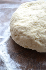 Raw wheat dough on cutting board on a white background