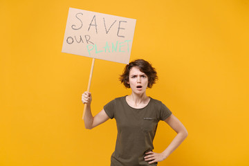 Shocked young protesting woman hold protest sign broadsheet placard on stick isolated on yellow background studio portrait. Stop nature garbage ecology environment protection concept. Save planet.