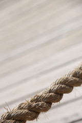 Aged rope with wooden floor boards in the background creating a natural aged texture for use as a background.