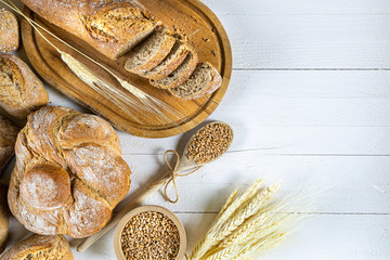 Fresh traditional bread on a brown wooden board with wooden spoon