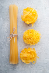 Gluten free food.Raw pasta with ingredients for cooking. Italian food.Gluten-free cornmeal products. Types of pasta: Manicotti, Bucatini, Fettuccini, Ditalini, Conquilla.
